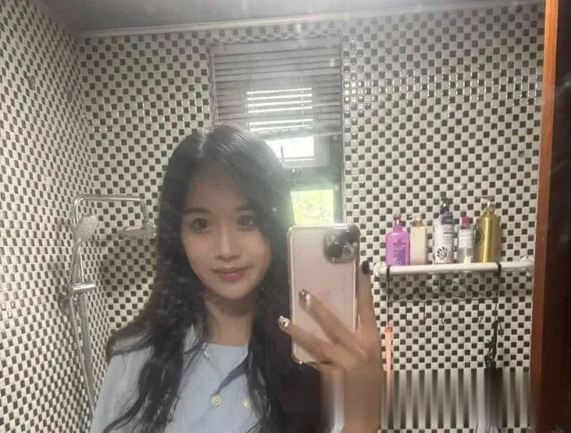 长发女孩蓝上衣浴室镜子自拍，粉色手机壳，甜美清新笑