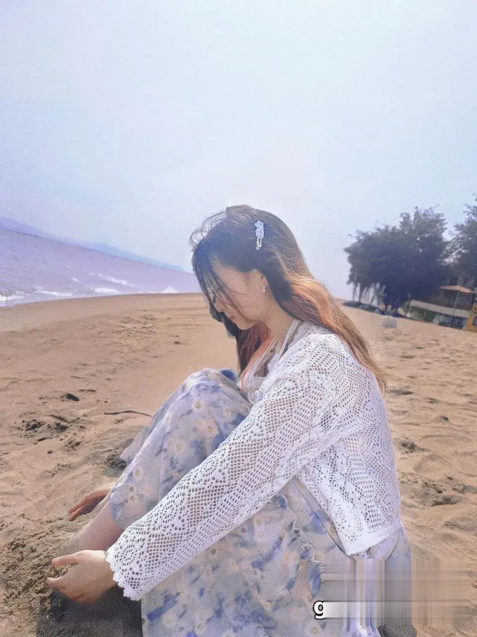 沙滩上白嫩美少女跪坐撩人姿势，风吹长发勾魂欲滴