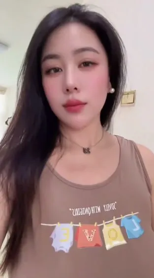 棕色背心女孩室内自拍，长发红唇温柔微笑，彩色图案上衣清新可爱日常风