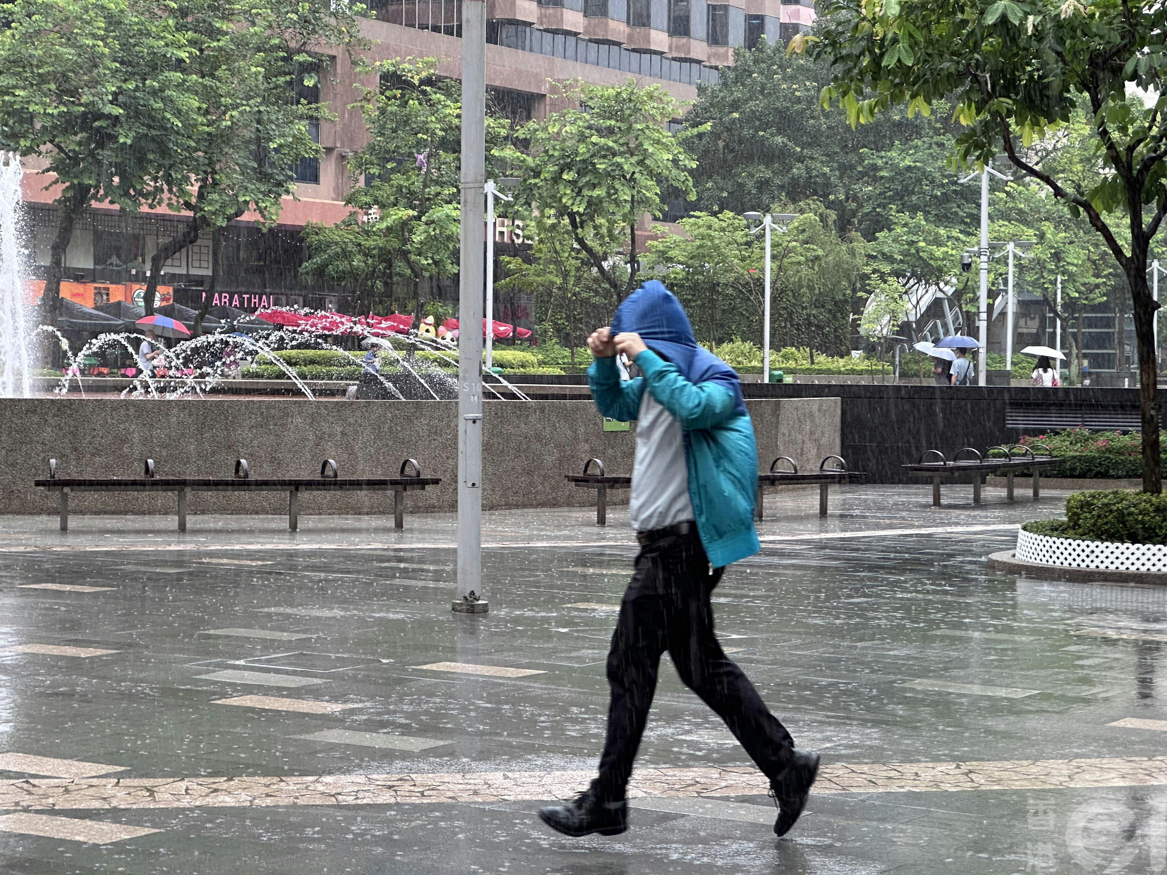 7月16日中午时分尖东忽然下大雨,无带雨伞市民只好在雨中急步走。(倪清江摄)