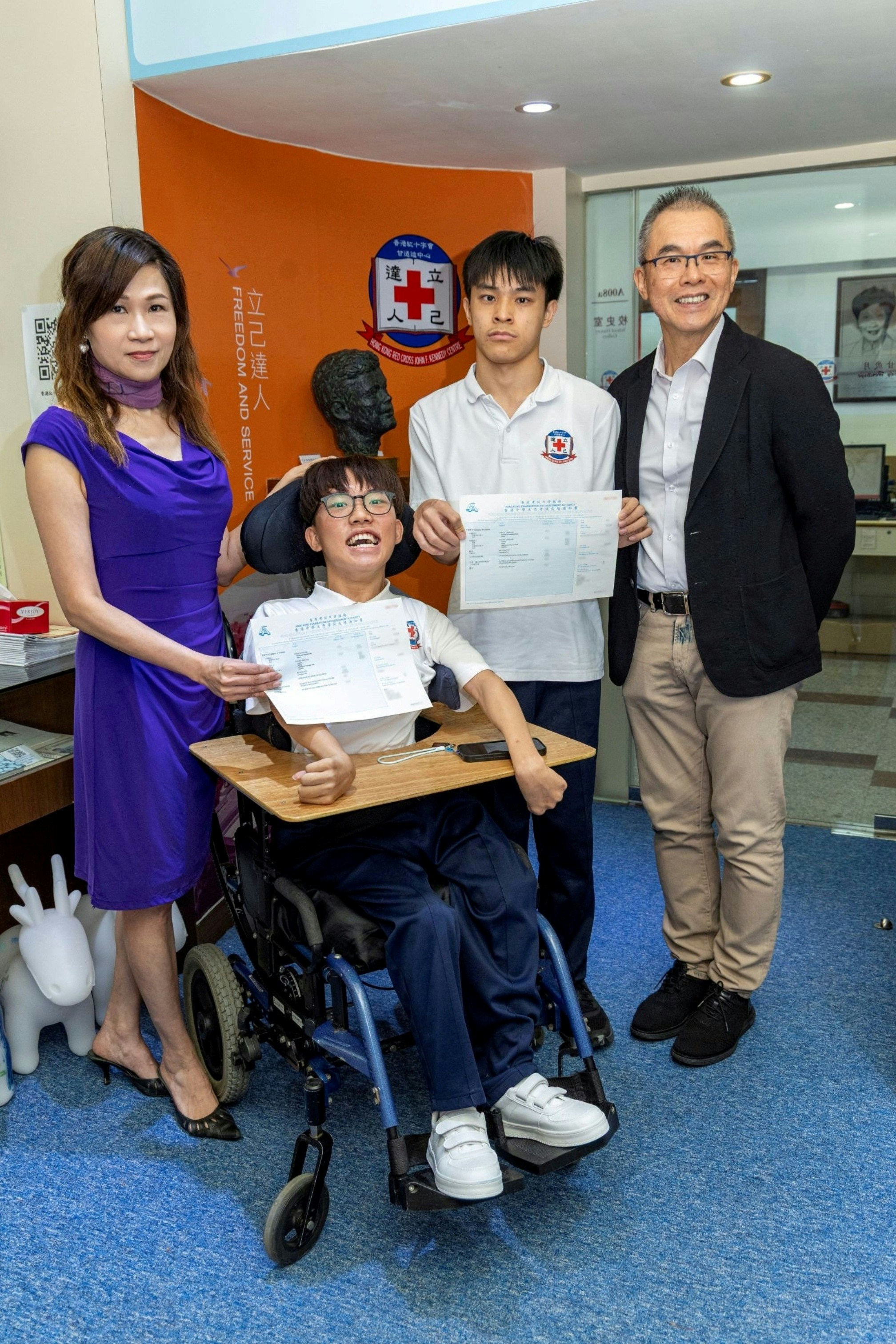 红十字会肯尼迪中心校长李静雯与考评局公开考试总监麦劲生向两名考生派发成绩通知书
