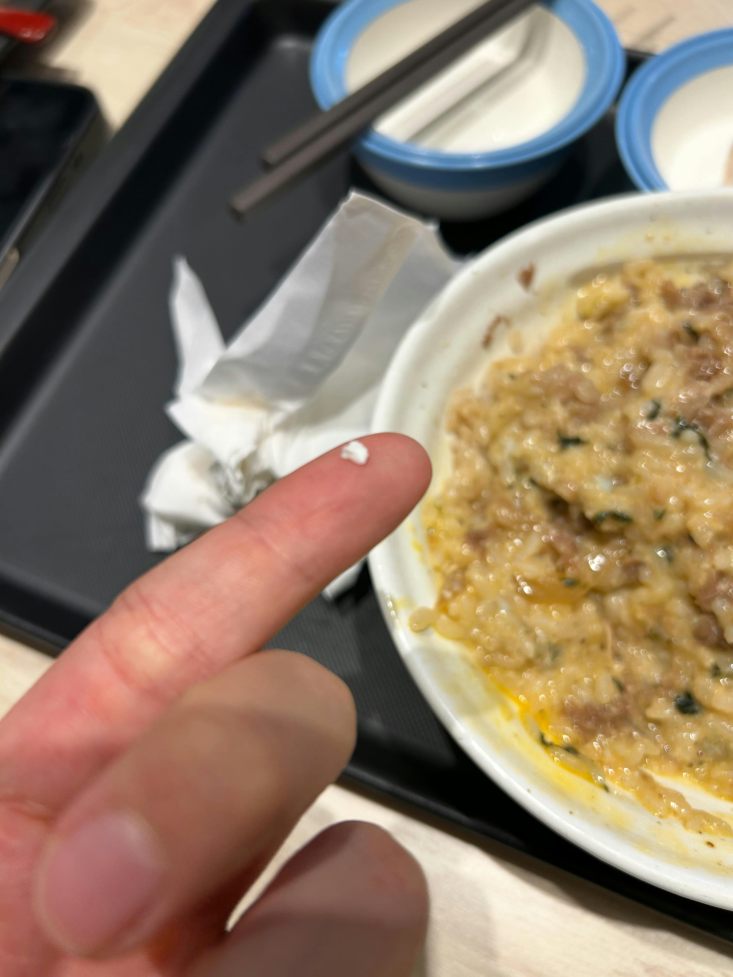 食客拍摄的牛肉饭中发现的白色颗粒物，疑为瓦片碎片