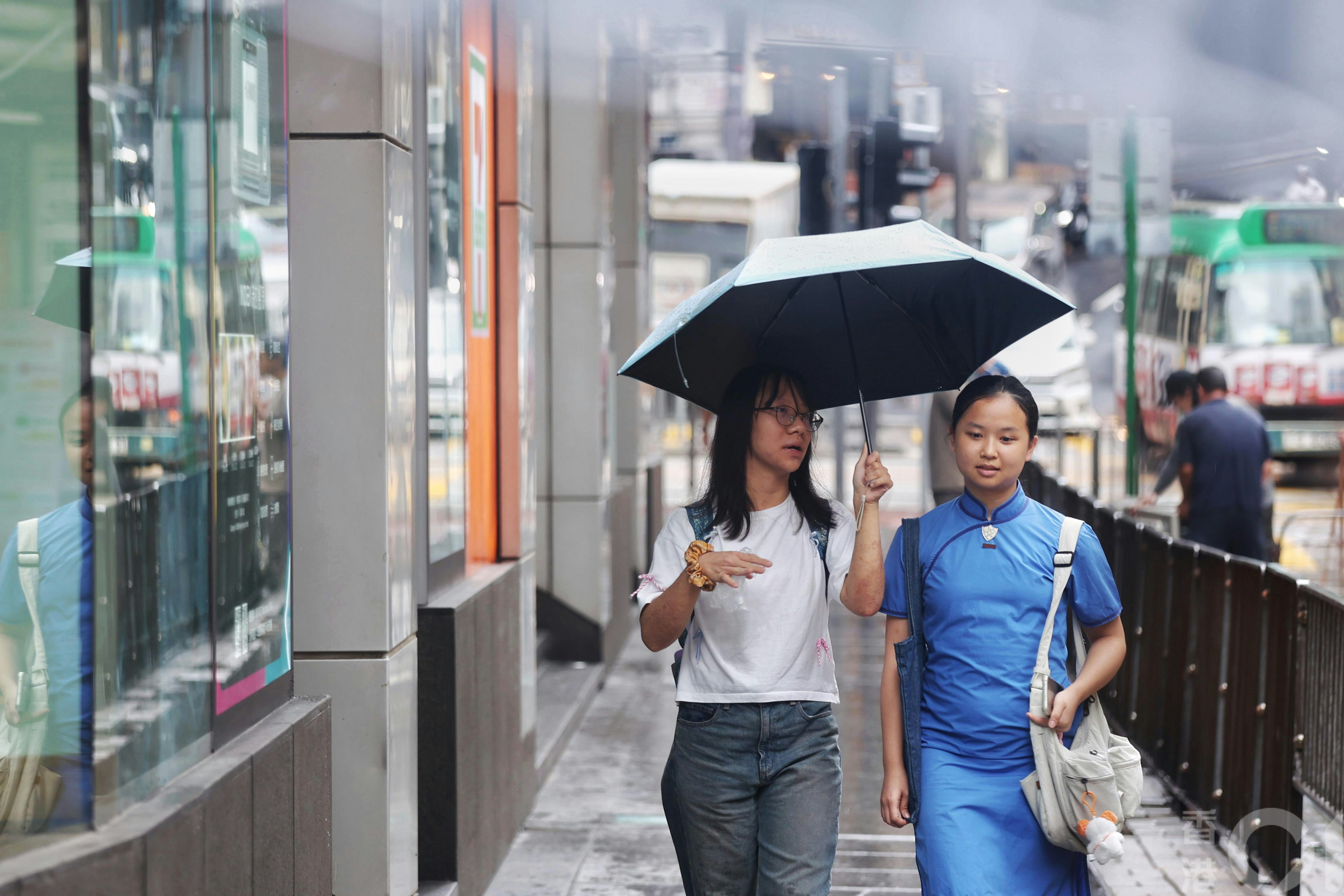 炮台山一带市民冒雨出行,多数人手撑雨伞