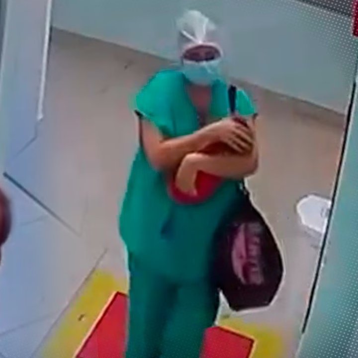 嫌犯抱着裹红毯的婴儿走向检查室