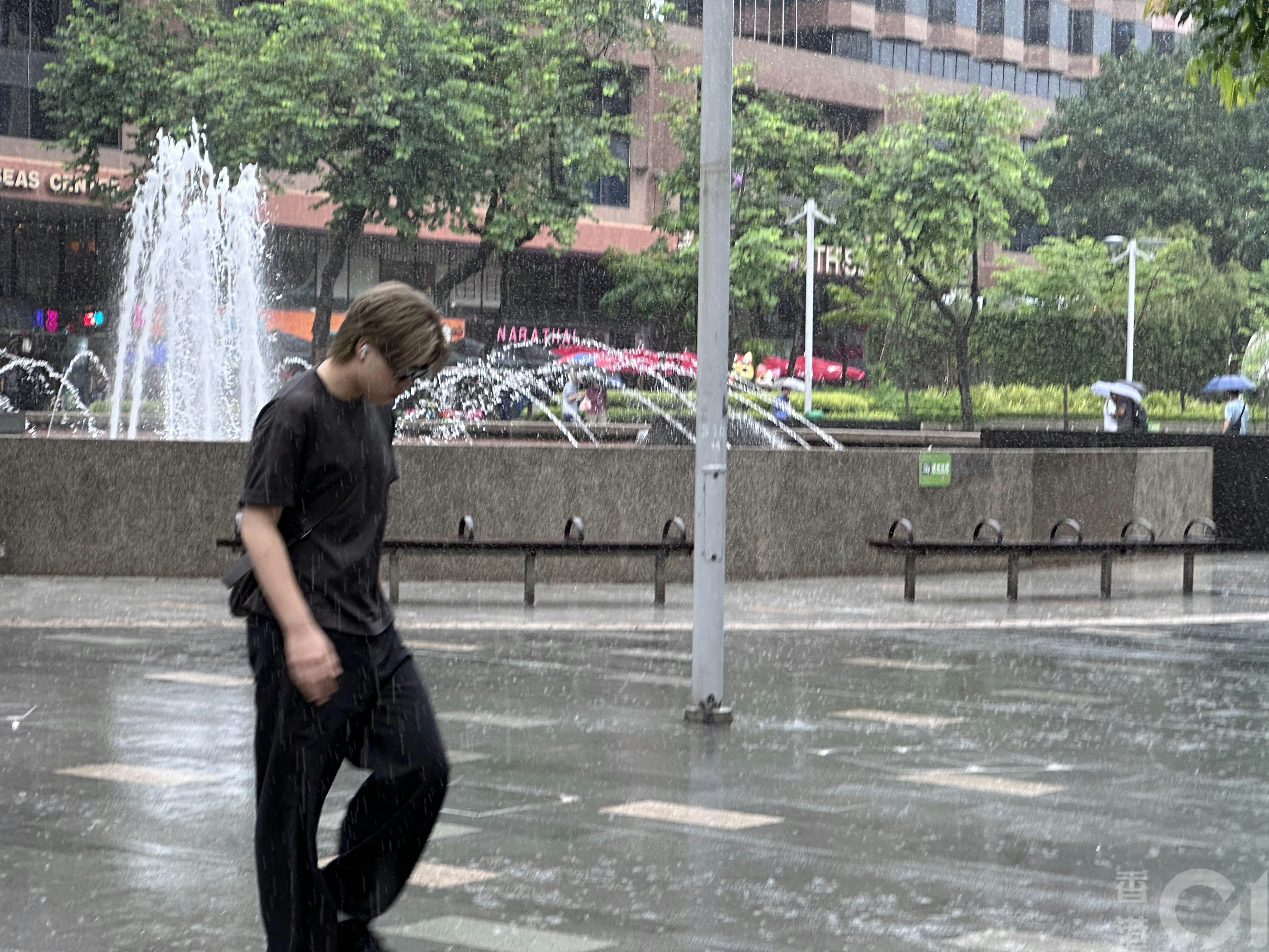 7月16日中午时分尖东忽然下大雨,无带雨伞市民只好在雨中急步走。(倪清江摄)