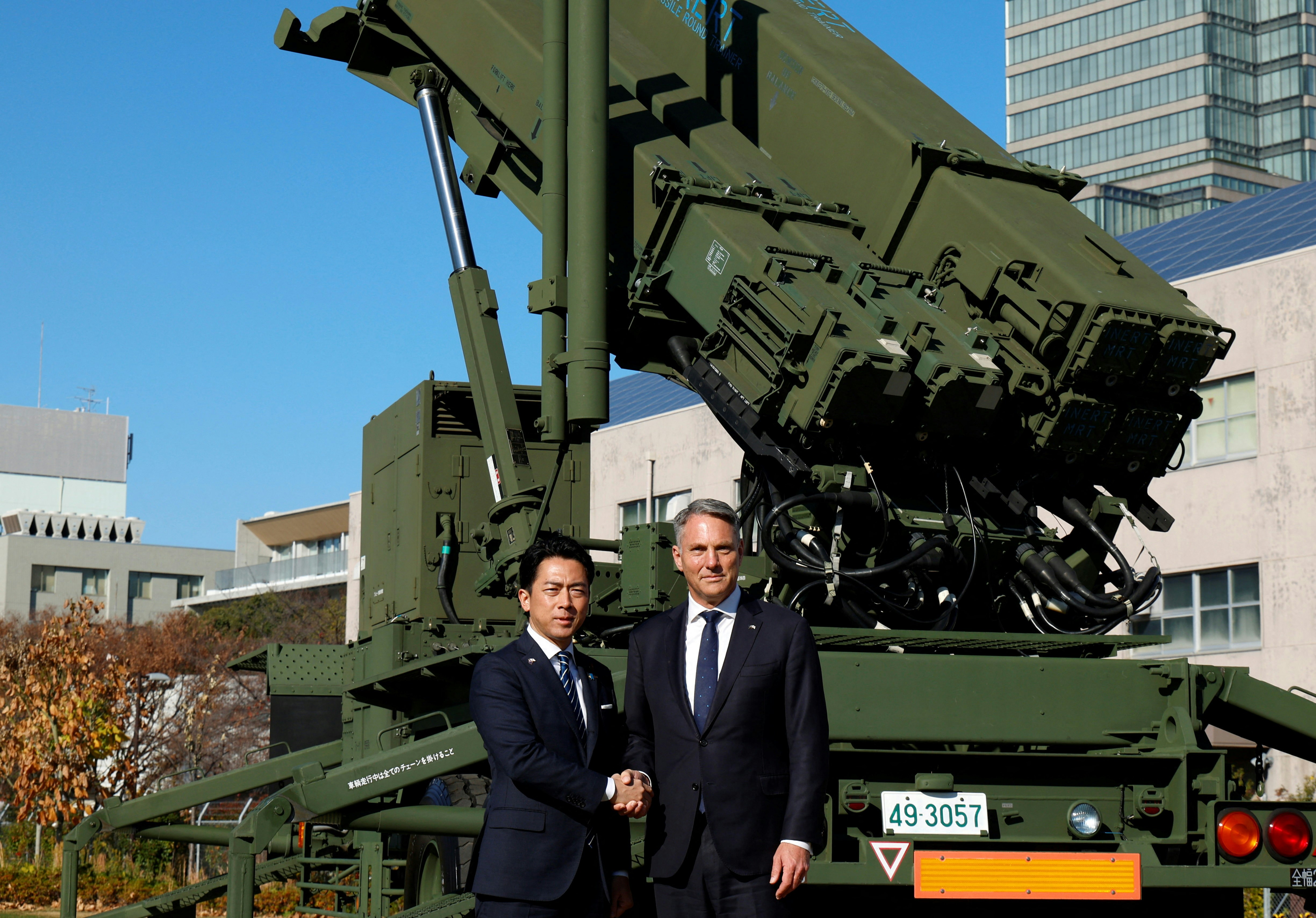 2025年12月7日,日本防卫大臣与澳洲国防部长在爱国者导弹装置前握手